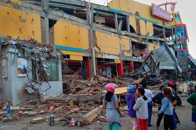 Warga melihat bangunan pusat perbelanjaan yang ambruk akibat gempa di Palu, Sulawesi Tengah, Sabtu (29/9/2018).