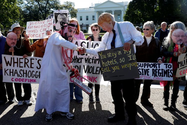 Aktivis berpakaian sebagai Putra Mahkota Saudi Mohammad bin Salman dan Presiden Amerika Serikat Donald Trump saling berjabat tangan dalam aksi demo menyerukan sanksi bagi Arab Saudi dan memprotes hilangnya jurnalis Saudi Jamal Kashoggi, di depan Gedung Putih, Washington, Amerika Serikat, Jumat (19/10/2018).