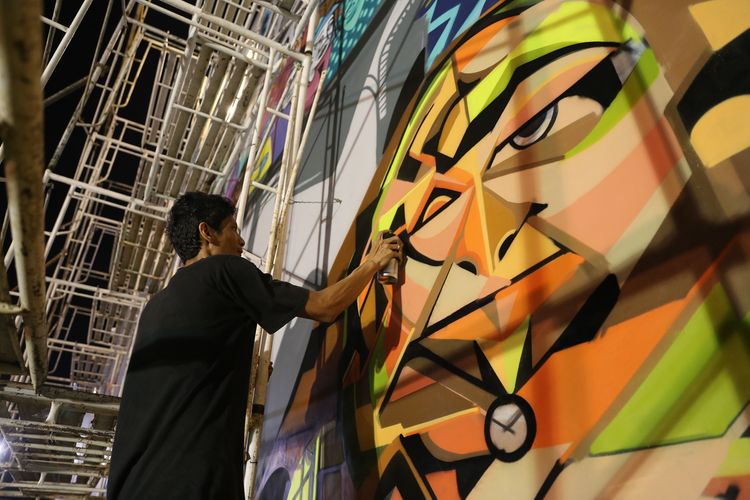 Seniman graffiti (bomber) sedang mengerjakan mural dengan tema Kalijodo dan sejarahnya di Ruang Publik Terpadu Ramah Anak (RPTRA) Kalijodo, Jakarta, Rabu (8/2/2017). Pengerjaan grafiti dan mural yang dilakukan ArtSip Jakarta 2017 dimulai pada Minggu (5/2/2017) sore dan melibatkan 11 seniman grafiti atau bomber.