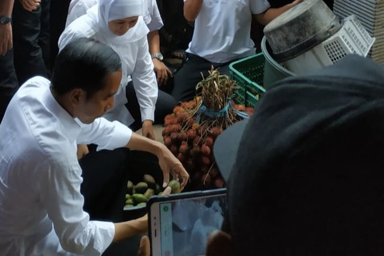 Jokowi memilih tomat dan kedongdong, lalu ditimbang sendiri di Pasar Wonoasih.
