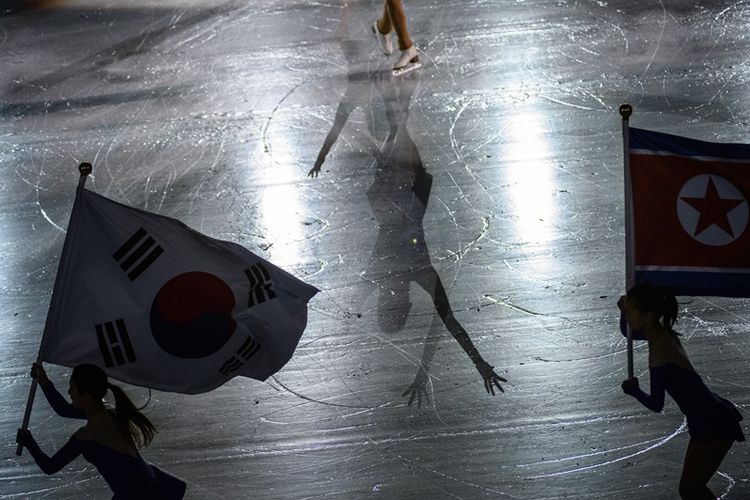 Atlet ski membawa bendera Korea Selatan dan Korea Utara saat penutupan kejuaraan ski di Taipei, Sabtu (27/1/2018).