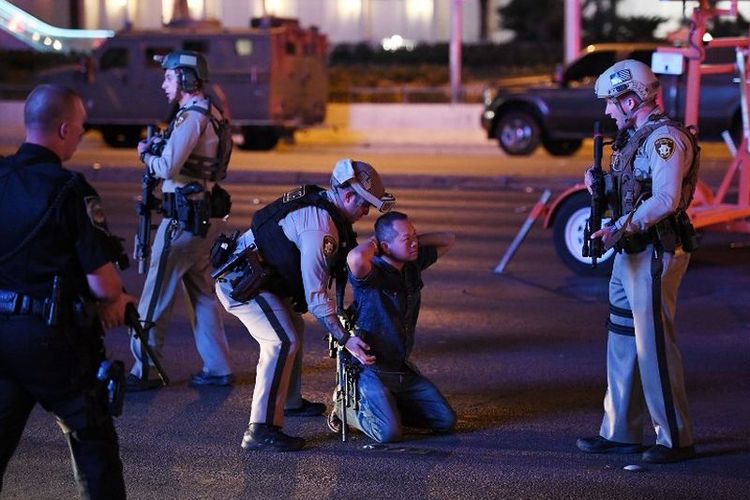 Polisi menghentikan seorang pengendara di Tropicana Ave. dekat Las Vegas Boulevard dan Tropicana Ave, pasca-penembakan massal di sebuah festival musik country di Las Vegas, Nevada, Minggu 91/10/2017). Pria itu akhirnya dilepaskan.