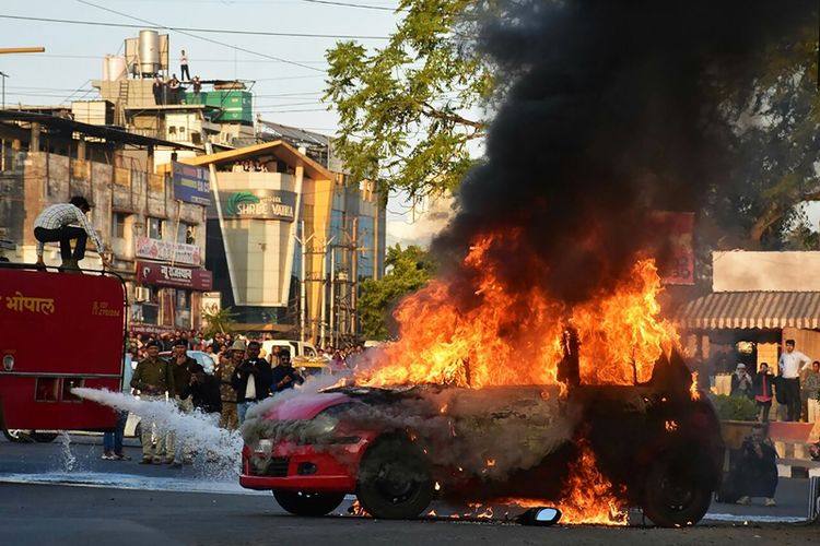 Sebuah mobil dibakar massa yang memprotes pemutaran film Padmavaat di kota Bhopal, India.