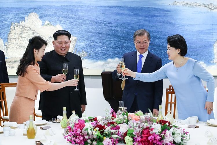 Pemimpin Korea Utara Kim Jong Un (dua dari kiri) didampingi oleh istrinya Ri Sol Ju (kiri), ketika bersulang dengan Presiden Korea Selatan Moon Jae In (dua dari kanan) dan Ibu Negara Kim Jung Sook (kanan) dalam jamuan makan malam saat KTT Antar-Korea Jumat (27/4/2018).