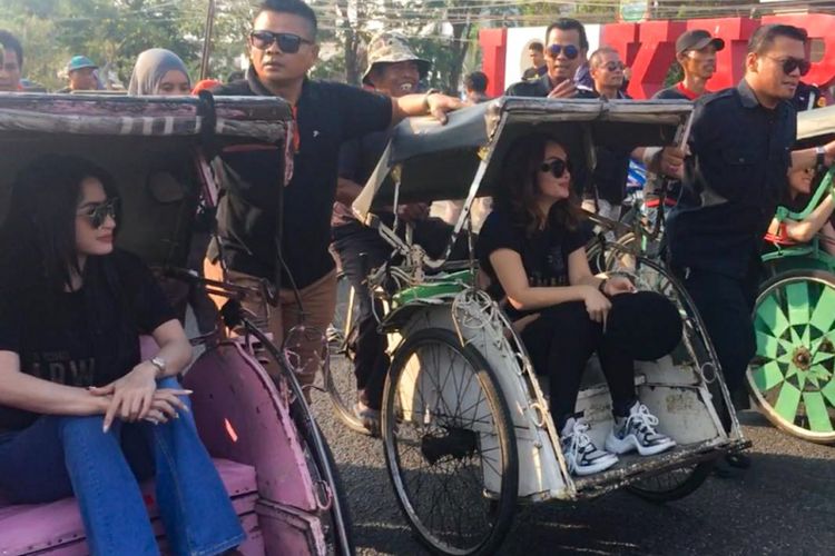 Penyanyi dangdut Dewi Perssik, Ayu Ting Ting dan Zaskia Gotik naik becak dalam rangka promosi film Arwah di Karawang, Jawa Barat, Sabtu (22/9/2018).