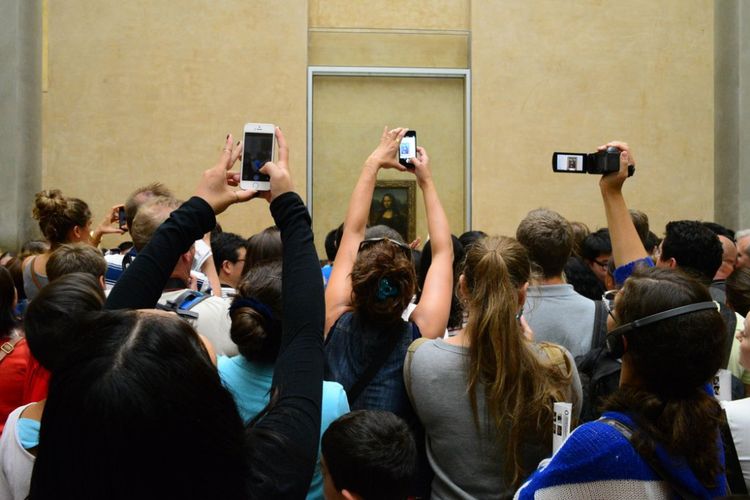Turis memotret lukisan Mona Lisa di Paris.