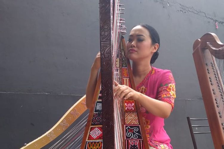 Musisi asal Bandung, Sisca, tengah memainkan harpa toraja. 