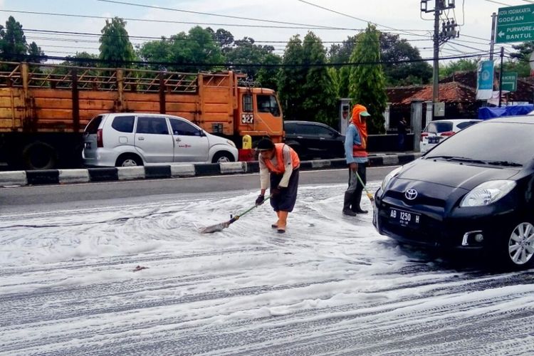 Petugas Bina Marga DIY saat membersihkan sisa busa di Jalan Laksda Adisucipto, Caturtunggal, Depok, Sleman, tepatnya di depan Rumah Makan Ayam Goreng Ny Suharti.