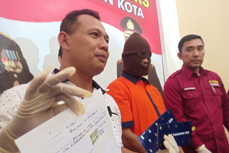 Aparat Polres Madiun Kota menunjukkan barang bukti dan tersangka penipuan berkedok penerimaan CPNS yang menelan korban guru honorer SD di Kota Madiun, Kamis (21/2/2019). 