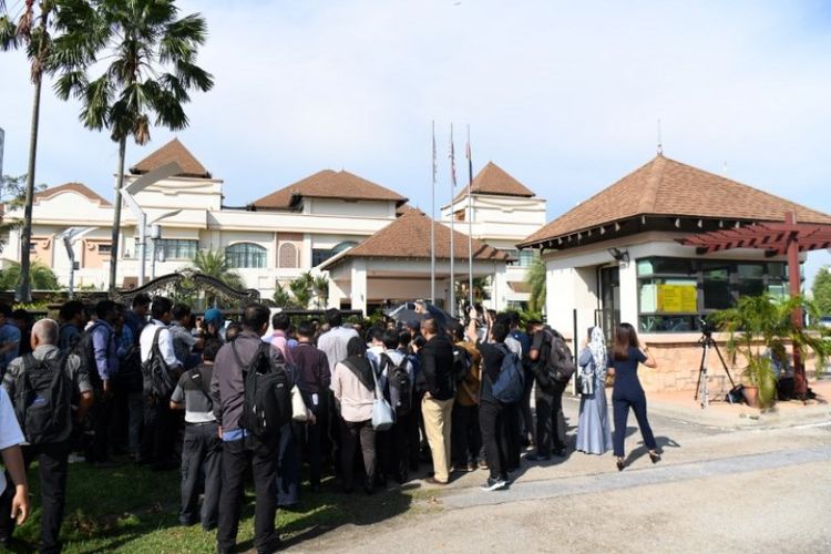 Awak media berkumpul di depan pintu masuk Perdana Leadership foundation di Putrajaya, Malaysia, Senin (14/5/2018) untuk menyambut kehadiran Perdana Menteri Mahathir Mohamad yang resmi berkantor. (AFP/Roslan Rahman)