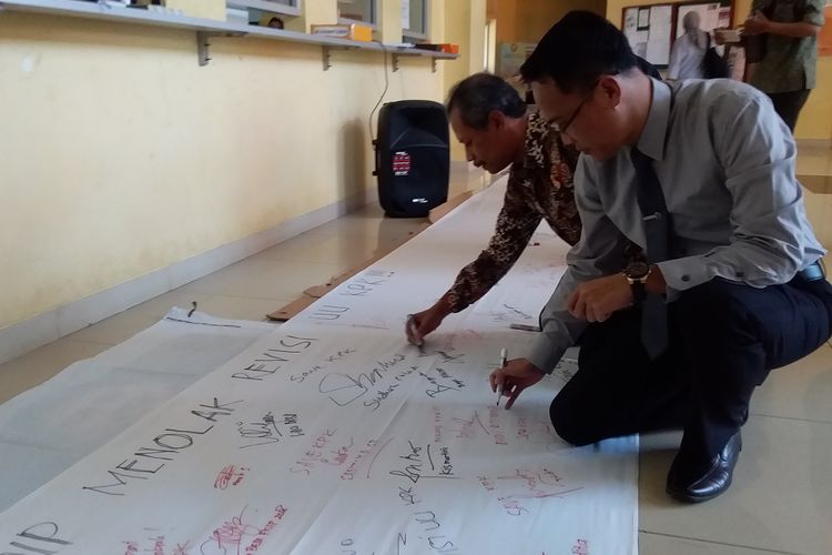 Wakil Rektor I Undip Budi Setiyono saat menandatangani petisi Seruan Penolakan Dosen Universitas Diponegoro Atas Revisi UU KPK di Lobi Kampus Fisip Undip Tembalang, Semarang, Senin (9/9).