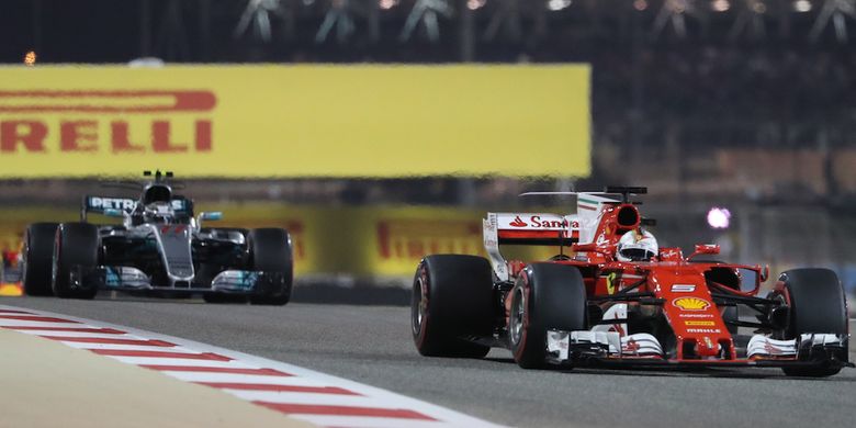 Pebalap Ferrari asal Jerman, Sebastian Vettel (depan), memacu mobilnya di depan pebalap Mercedes asal Finlandia, pada balapan GP Bahrain di Sirkuit Internasional Bahrain, Sakhir, Minggu (16/4/2017).