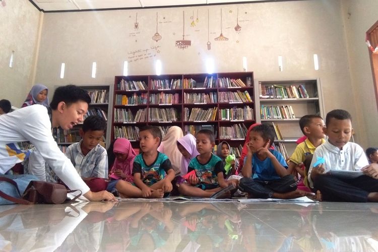 Fityan Yudhan, Public Relations Gramedia mengajari anak-anak membaca di Rumoh Baca, Hasan Savvaz di Desa Jambo Timu, Kecamatan Blang Mangat, Kota Lhokseumawe, Aceh, Sabtu (18/8/2018). 