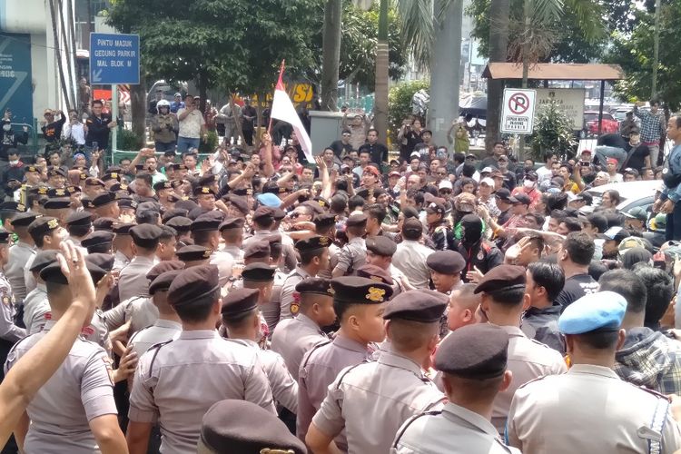 Massa aksi mencoba masuk ke dalam kantor Gojek. Massa dan polisi sempat melakukan aksi saling dorong di depan kantor Gojek, Senin (5/8/2019).