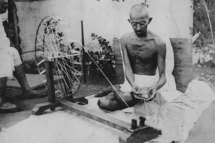 Mahatma Gandhi sedang memintal kain. Foto ini diambil pada tahun 1920-an.