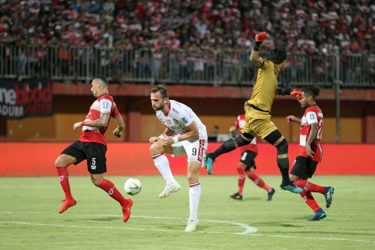 Penyerang Bali United, Ilija Spasojevic, berjibaku dengan para pemain Madura United pada lanjutan pekan ke-15 Liga 1 2019 di Stadion Gelora Ratu Pamelingan, Selasa (20/8/2019).