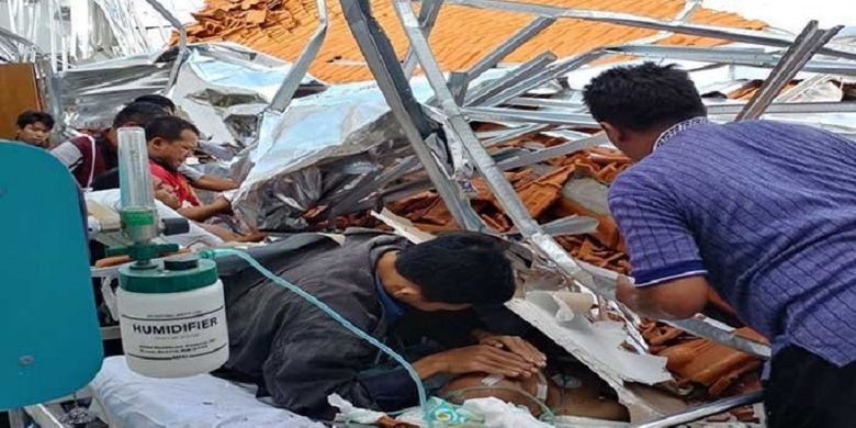 Pasien yang masih berada di antara puing reruntuhan salah satu ruang rawat inap RSAL Dr Ramelan Surabaya yang ambruk pada Minggu (18/3/2018).