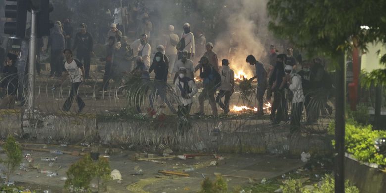Demonstran melempari polisi dengan batu saat terjadi kericuhan di dekat gedung Bawaslu, Jalan MH Thamrin, Rabu (22/5/2019).