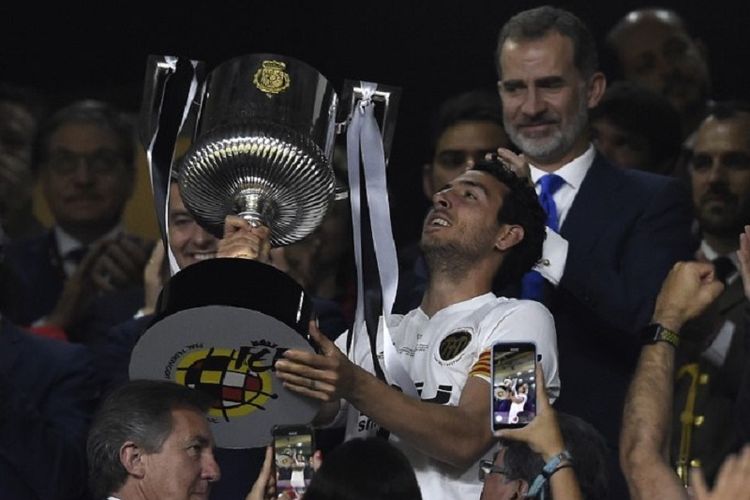 Kapten Valencia, Daniel Parejo, mengangkat trofi Copa del Rey seusai mengalahkan Barcelona pada laga final di Stadion Benito Villamarin, 25 Mei 2019. 