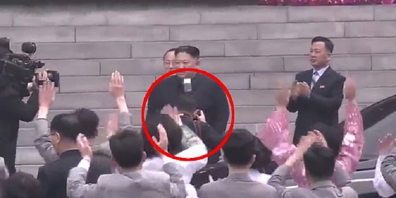 Inilah momen di mana fotografer bermarga Ri tertangkap mengarahkan kamera ke arah Pemimpin Korea Utara Kim Jong Un sehingga flash pun terlihat berada di leher. Ri langsung dipecat karena dianggap merusak kemuliaan tertinggi Kim.