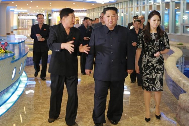 Pemimpin Korea Utara Kim Jong Un (tengah) dan istrinya, Ri Sol Ju (kanan), mengunjungi restoran seafood di dekat Sungai Taedong yang baru dibangun di Pyongyang. (KCNA via KNS/AFP)