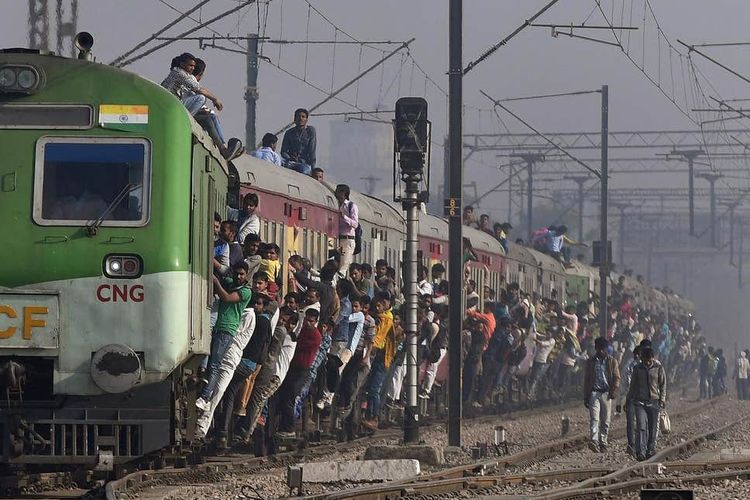 Masyarakat India bergelantungan hingga naik ke atas kereta api.