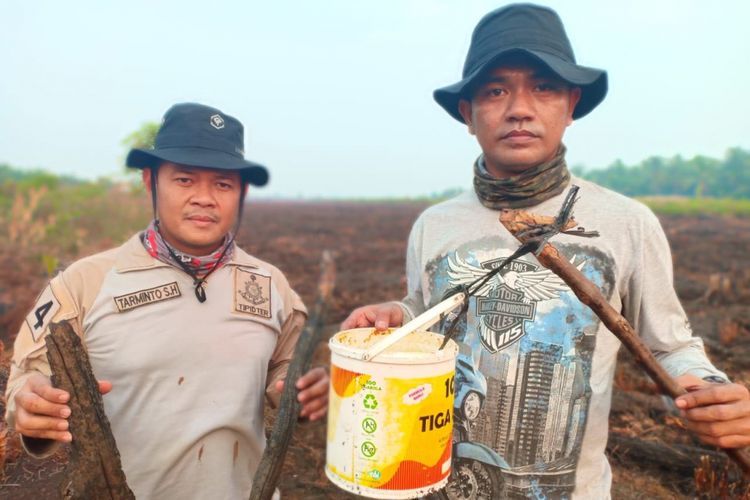 Kasat Reskrim Polresta Pontianak Kompol Husni Ramli (kanan) menunjukkan barang bukti usai olah TKP di lokasi lahan yang terbakar di Jalan Parit Sarem, Desa Punggur, Kecamatan Sungai Kakap, Kabupaten Kubu Raya, Selasa (21/8/2018)