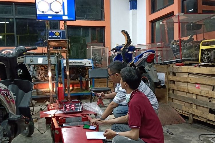 Alvin Rahmad Widyanto bersama rekannya sedang menguji katalitik konverter di knalpot sepeda motor.