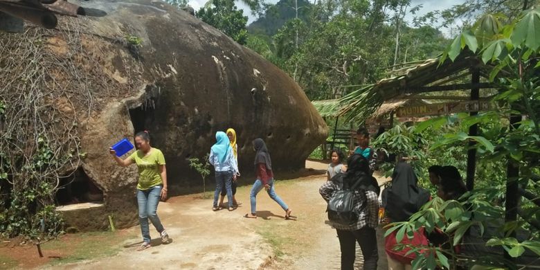 RUMAH BATU --Pengunjung masuk ke rumah batu milik Sutini di Dusun Mujing, Desa Genengharjo, Kecamatan Tirtomoyo, Kabupaten Wonogiri, Jawa Tengah.
