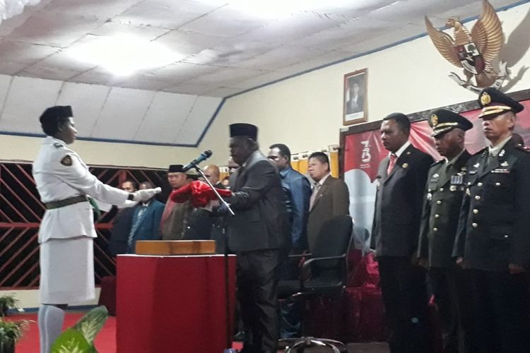 Bupati Asmat Elisa Kambu ketika menyerahkan duplikat bendera merah putih kepada seorang anggota paskibra, Kamis (16/8/2018) malam