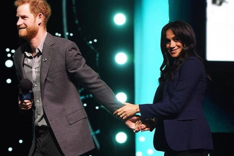 Pangeran Harry menarik Meghan MArkle ke atas Panggung WE Day