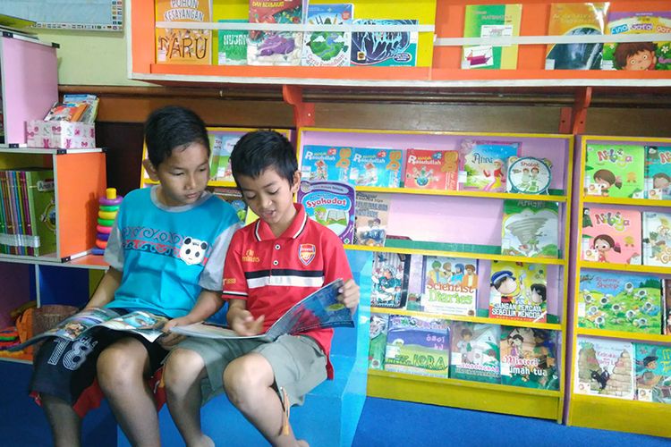 Anak-anak membaca di Taman Bacaan Masyarakat Rumah Pelangi di Desa Suci, Kecamatan Manyar, Gresik, Jawa Timur.