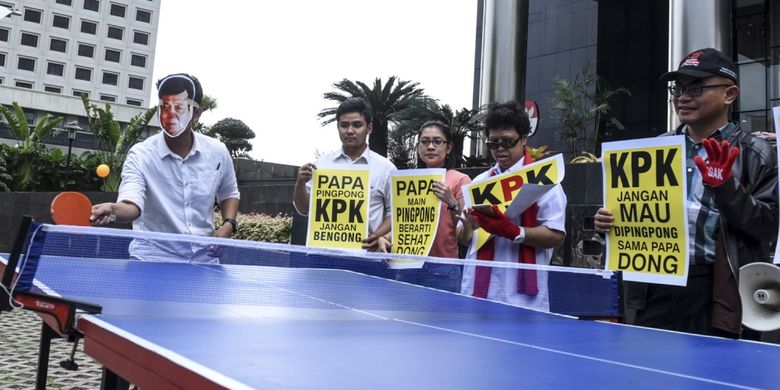 Aktivis yang tergabung dalam Koalisi Save KPK mengenakan topeng wajah Ketua DPR Setya Novanto saat aksi teatrikal permainan tenis meja melawan KPK saat melakukan aksi di depan gedung KPK, Jakarta, Rabu (18/10). Aksi yang dibalut dengan parodi pertandingan Tenis Meja tersebut untuk mendesak KPK menetapkan kembali Ketua Umum Partai Golkar itu sebagai tersangka kasus korupsi KTP elektronik.