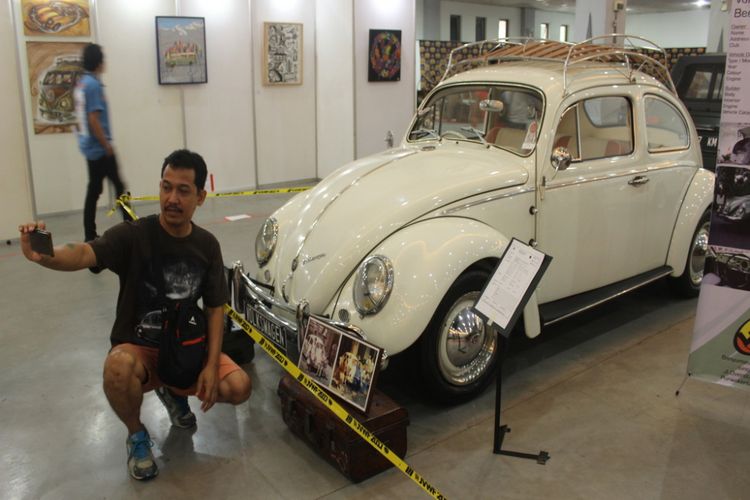 Pengunjung berswafoto dengan latar belakang mobil Volkswagen Beetle puith bernama Kesatria Putih di ajang Jogjakarta Volkswagen Festival (JVWF) 2017, Jogja Ekspo Center (JEC), Jalan Janti, Kabupaten Bantul, DI Yogyakarta, Minggu (19/11/2017).