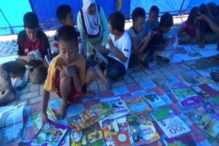 Sejak dua pekan tak sekolah karena gempa, relawan literasi Mamasa sulawesi barat menyediakan beragam buku bacaan di tenda pengungsian korban gempa Mamasa