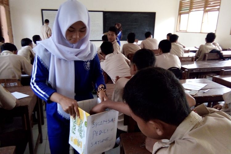 Salah seorang siswa menyisihkan uang sakunya untuk membantu korban banjir Sayung saat penggalangan dana yang dilakukan  oleh OSIS SMK Negeri Sayung,  Jumat (17/2/2017) pagi. 