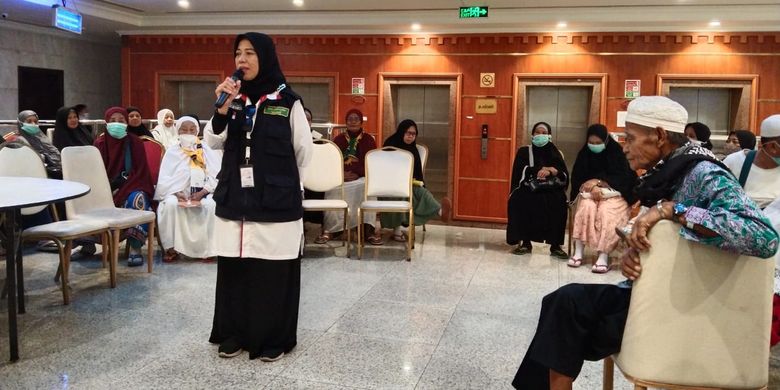 Petugas haji tahun 2023, Yuminah, saat memberikan penjelasan kepada jemaah lansia. 