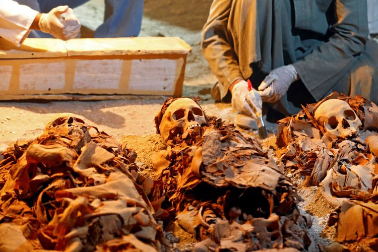 Para pekerja kepurbakalaan Mesir dengan tiga mumi yang ditemukan di makam Amenemhat.