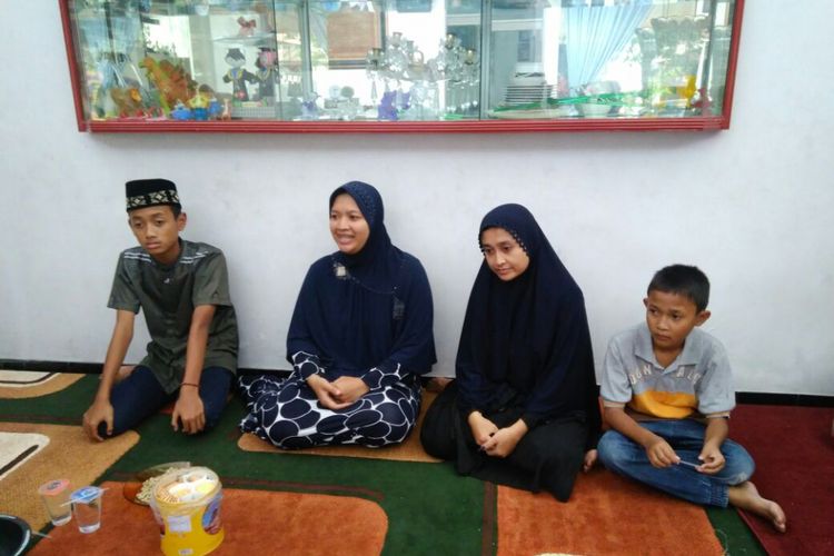 Istri mendiang kiper Persela Lamongan Choirul Huda, Lidya Anggraeni (kedua dari kanan) dan anak sulung Muhammad Rachul Maulana (kiri) serta anak bungsu Rafael Ramadhan (10).