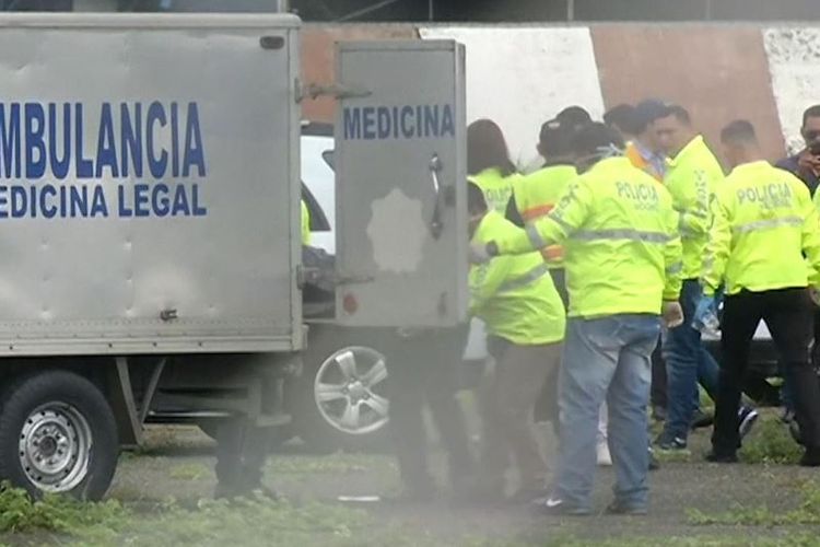 Tim medis di bandara Jose Joaquin de Olmedo, Guayaquil, Ekuador memindahkan jenazah dua pria dari landasan pacu.