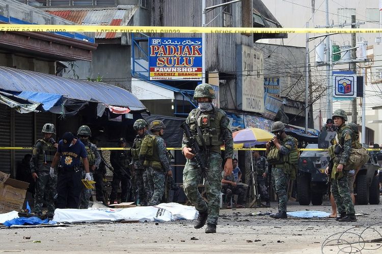 Polisi dan tentara mengamankan lokasi ledakan di sebuah gereja di Pulau Jolo, wilayah selatan Filpina pada Minggu (27/1/2019). 