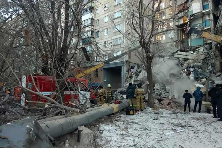 Petugas dari tim penyelamat sedang bekerja di lokasi terjadinya ledakan gas di kota Magnitogorsk di Rusia, Senin (31/12/2018).