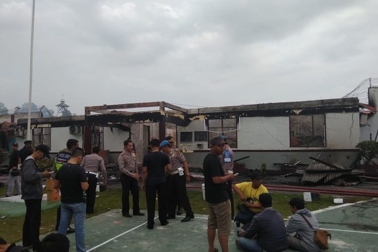 Petugas kepolisian melakukan pengamanan pasca kerusuhan dan pembakaran Rutan Kelas IIB Siak Sri Indrapura, Riau,  Sabtu (11/5/2019) dini hari. 