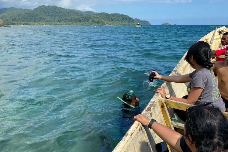 Salah satu mama anggota Jom Sak Sasi saat menunjukkan teripang hasil tangkapan dengan cara menyelam (molo) di lepas pantai Misool Utara, Raja Ampat, Papua Barat, Kamis (18/10/2023). Foto: Farid Assifa