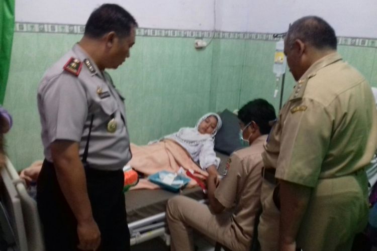 Petugas Polres Malang saat melihat siswa SD Islam Riyadlul Mubtadiin yang mengalami keracunan di Puskesmas Turen, Selasa (14/11/2017)