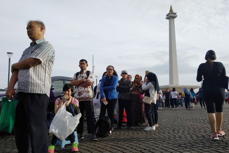 Antrian warga mengular di Monas, Minggu (21/1/2018). Warga mengantri untuk mendapatkan paspor dalan Festival Keimigrasian yang diadakan Ditjen Imigrasi.