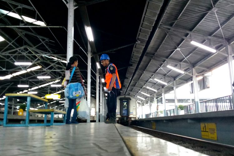 Seorang petugas tengah memberikan informasi kereta kepada pemudik yang tengah menggendong anak dan sejumlah barang di Stasiun Bandung.