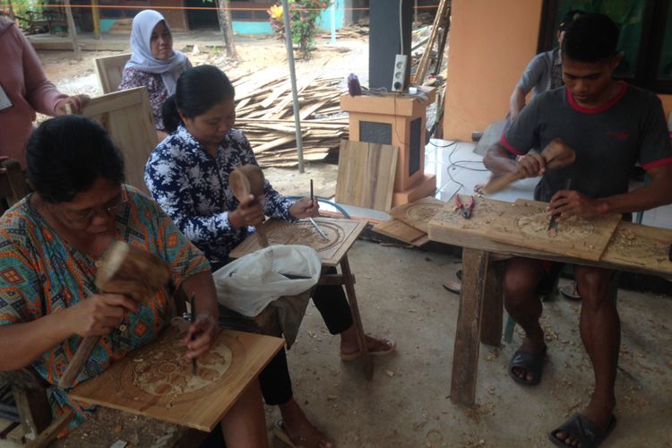 Para perempuan Jepara mengukir motif di atas papan kayu Jati di Desa Patekeyan, Kecamatan Tahunan, Jepara, Rabu (4/10/2017).