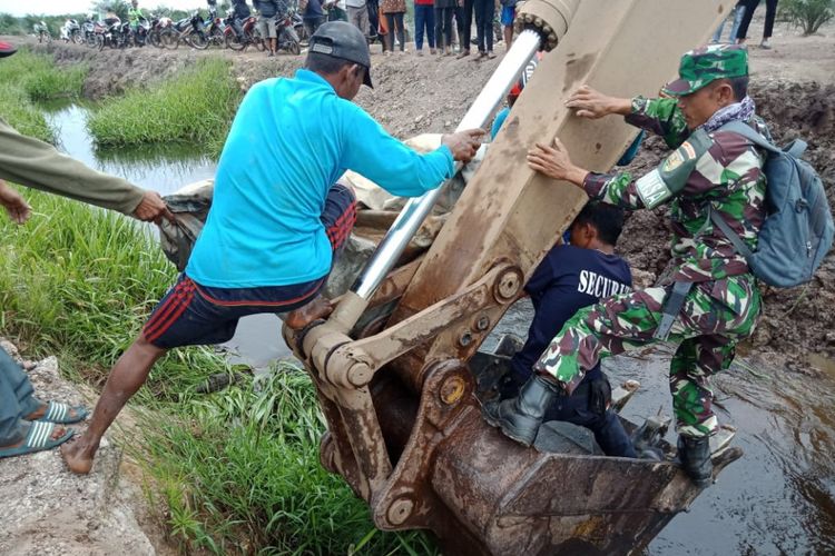 Warga serta TNI mengevakuasi jenazah Alif dengan menggunakan alat berat. Alif sebelumnya dikabarkan tewas diterkam buaya saat memancing di areal wilayah PT KAM Blok C, Kabupaten Banyuasin, Sumatera Selatan, Selasa (10/7/2018)