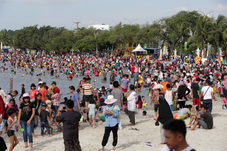 Pengunjung memanfaatkan liburan mengunjungi pantai di kawasan Taman Impian Jaya Ancol, Jakarta, Selasa (27/6/2017). Sejumlah lokasi wisata di Jakarta padat pengunjung pada libur lebaran. 